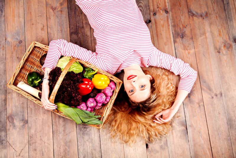 Girl with a basket full of vegetables